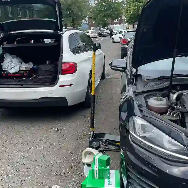 AutoDr working on a car at the kerbside with the boot and bonnet open